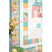A closer look at the quilt at a slight angle, showing color and print details on the pink, yellow, and blue fabrics.