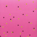 A pink fabric swatch with various-sized dots in dark purple and gold scattered throughout.