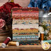 A stack of floral fabrics included in the Farmer's Daughter Fat Quarter Set, with flowers and thread and a milk tin.