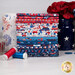 A stack of the fabrics included in the Patriotic Minis FQ bundle, with jars and flowers and buttons and a candle and thread.