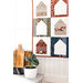A quilt featuring house designs hangs on a wall next to a potted plant and cutting boards.