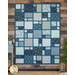 The Views quilt, featuring various woodland patterns in blue, teal, and white, displayed against a wooden backdrop.