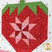 A close up on one of the strawberry blocks, showing fabric color, vibrancy, and pattern details.