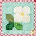 A close up on one of the strawberry flower blocks, showing fabric color, vibrancy, and pattern details.