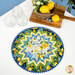 The completed Point of View Folded Star Table Topper colored in yellow, green, and blue fabrics from the Limoncello collection. The topper is staged on a white table with coordinating summer and lemon-themed decor.
