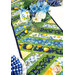 A close up on the patchwork of the table runner staged with a coordinating vase of flowers, demonstrating fabric and piecing details.