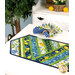 A shot of the table runner on a table staged with coordinating fabric napkins and summer and lemon-themed decor in the background.