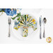 A top down shot of a place setting with the reversible white lemon text fabric of the napkin faced out.
