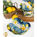 A shot of an empty bowl cozy with a stack of the other cozies in the background, all staged on a white table with coordinating florals and lemon decor.