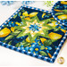 A stylized shot of the square hot pad, taken at a slight angle and demonstrating details on the blue and green fabrics.