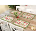 A wide shot of the four placemats on a wood table with coordinating florals in a vase at the center.