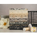 A stack of the fabrics featured in the Posh FQ set, with a basket and books and a flower and thread.