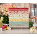 A stack of the fabrics featured in the Lyda Rose FQ set, with flowers and a pitcher and a bird and thread.
