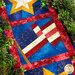 A shot of the American flag in the center surrounded by decorative leaves, demonstrating fabric, sashing, border, and binding details.