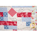 A colorful quilt featuring floral patterns and motivational text, in red, blue, and cream fabrics.