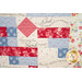 Patchwork quilt featuring floral patterns and biblical text, in red, blue, and cream.