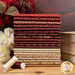 A fabric stack featuring fat quarters in red and cream patterns, with books and flowers and thread.
