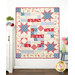 The Comfort of Psalms Quilt - Hollyhocks & Roses in red, blue, and cream, displayed against a light wall next to surrounding decor
