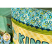 A close up on the pillow showing color and pattern details on the fabrics and scalloped border.