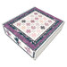 Decorative box with floral and star patterns in pink, purple, and teal on a cream background.