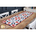 The completed Just a Sliver Tablerunner, colored in red, white, blue, and navy fabrics from the Grand Haven collection by Moda Fabrics, staged on a rustic wooden table.