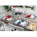 A dining table set with red and blue patterned placemats, plates, glassware, and a patriotic vase.
