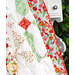 A close up of the quilt draped over a white hutch, demonstrating fabric, piecing, border, binding, and stitching details.