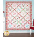 A large summer quilt colored in red, green, pink, and blue floral fabrics from the Berry Sweet collection, hung on a blue paneled wall and bordered by coordinating red and pink florals and decor.