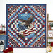 The completed Trip Around The World Panel Quilt colored in patriotic red, white, and blue fabrics from the Stars & Stripes 13 collection, hung on a white-paneled wall and bordered by coordinating Americana decor.