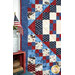 An angled shot of the left side of the quilt, demonstrating fabric, piecing, border, and binding details. Small American flags sit in a milk can on the left side of the frame.