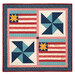 The completed July Pieceful Patchwork wall hanging, colored in cream, red, blue, and teal fabrics from the Americana collection by Lori Holt for Riley Blake Designs, isolated on a white background.