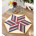 The completed 60 Degree Diamond Table Topper Kit colored in red, cream, blue, and yellow fabrics from the Old Glory collection by Henry Glass fabrics, staged on a rustic table with coordinating decor.