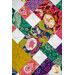 A close up on the quilt, demonstrating the vibrant fabrics and woven effect of the patchwork.