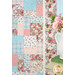 A pink, blue, and cream patchwork quilt featuring floral and paisley patterns is displayed beside a vase of pink roses.