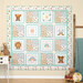 The completed Be Strong and Courageous Quilt colored in crisp white, aqua, and brown baby fabrics from the Boho Buddies collection, hung on a paneled tan wall with coordinating baby decor like a soft blanket hung over a ladder and stuffed animals.