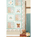 A shot of the right side of the quilt, hung next to a soft blanket draped over a wooden ladder and a stuffed bear in a small red wagon.