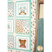 An angled shot of the right side of the quilt next to a blanket staged over a ladder, demonstrating fabric, cornerstone, border, sashing, and binding details.