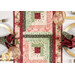 A top-down shot of the table runner on the set white table with place settings, showcasing the log cabin piecing.
