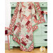 The patchwork quilt artfully draped over a mint green armoire set with coordinating decor and florals.