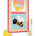 A close up on the bottom bee block of the project, with part of the honeypot peeking into frame from the top. Coordinating bee-themed decor sits below the project.