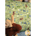 An angled shot of the Magic Pillowcase in green, staged on a bed with a matching patchwork quilt and moose plushie in a cabin setting.