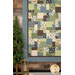 A shot of the bottom left corner of the quilt, staged next to a small tree and rustic lantern.