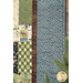 A close up shot of the outer quilt edge, demonstrating fabric, piecing, border, binding, and stitching details.