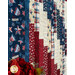 A close-up of a patriotic quilt featuring red, white, and blue fabrics with star and plaid patterns.