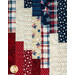A patchwork quilt featuring red, white, and blue fabrics with stars, stripes, and polka dotted designs.