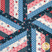 A super close up on the center of the topper where all the patchwork diamonds meet, demonstrating fabric color and print details.