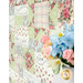 A stylized close up on the patchwork of the quilt, demonstrating fabric color and print details; coordinating flowers peek into frame from the left side.
