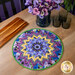 The Table Topper colored in vibrant purple fabrics from the Pansy Perfection collection, staged on a wooden table with coordinating flowers and glass ware.