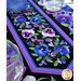A close up on the center of the runner, demonstrating vibrant color details on the pansy themed fabric.