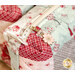 A super close up on the zipper pull tab, a cherry blossom flower with gold metal accents.